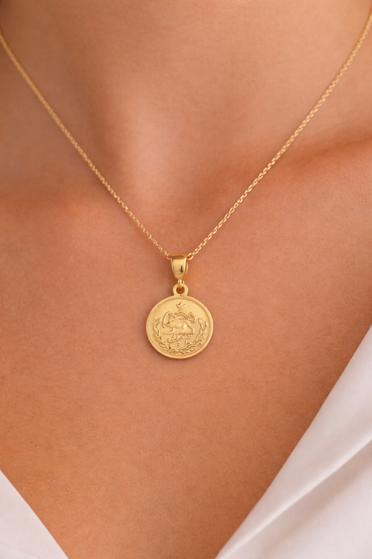 Iranian Gold necklace with a round pendant on a person's neck
