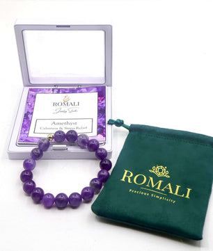 ROMALI 18K gold-plated natural amethyst beaded bracelet in packaging and pouch, promoting calmness and emotional balance.