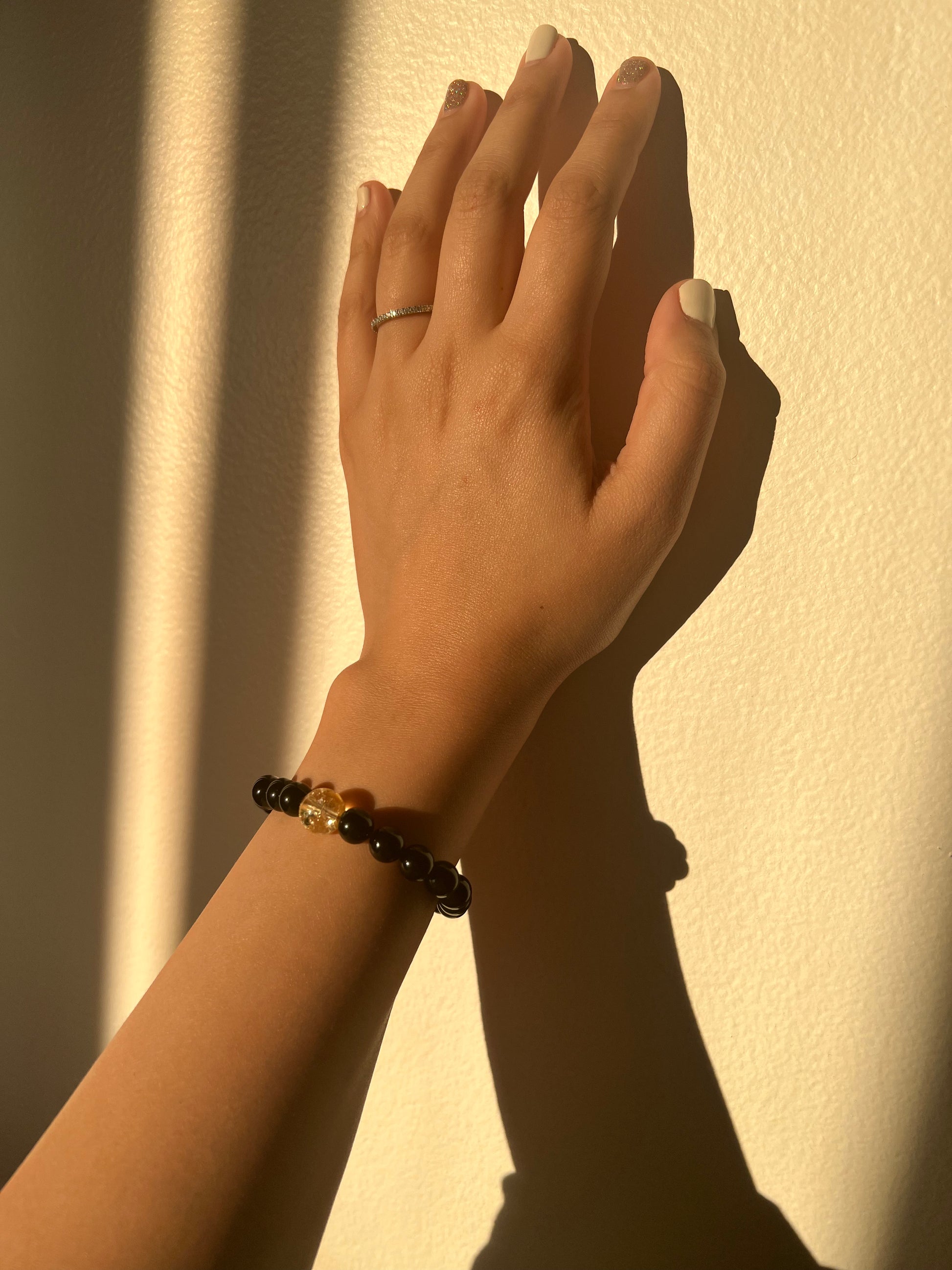 Hand with a ring and bracelet against a light background