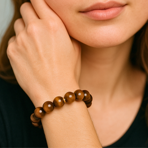 Close-up of a woman's hand wearing a wooden beaded bracelet.