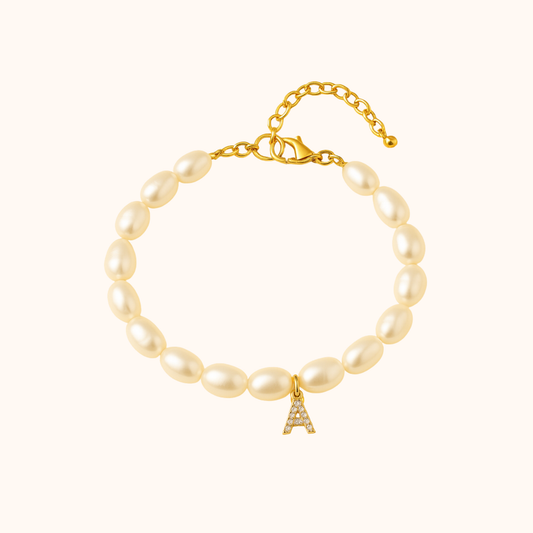 Pearl bracelet with a gold chain and letter 'A' charm on a white background