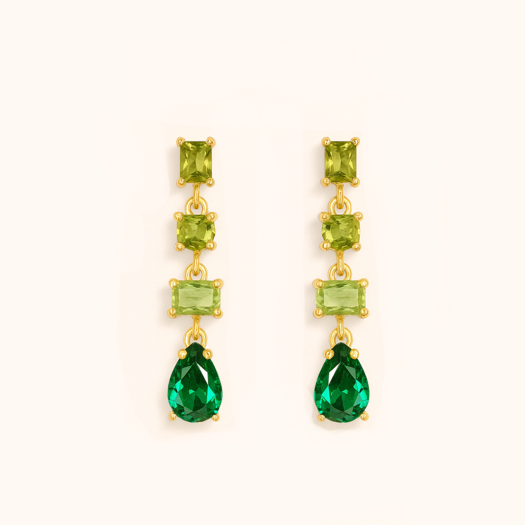 Pair of gold earrings with green gemstones on a white background