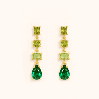 Pair of gold earrings with green gemstones on a white background