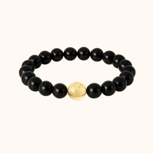 Black beaded bracelet with a gold accent bead on a white background