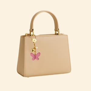 Beige handbag with a pink butterfly charm on a beige background