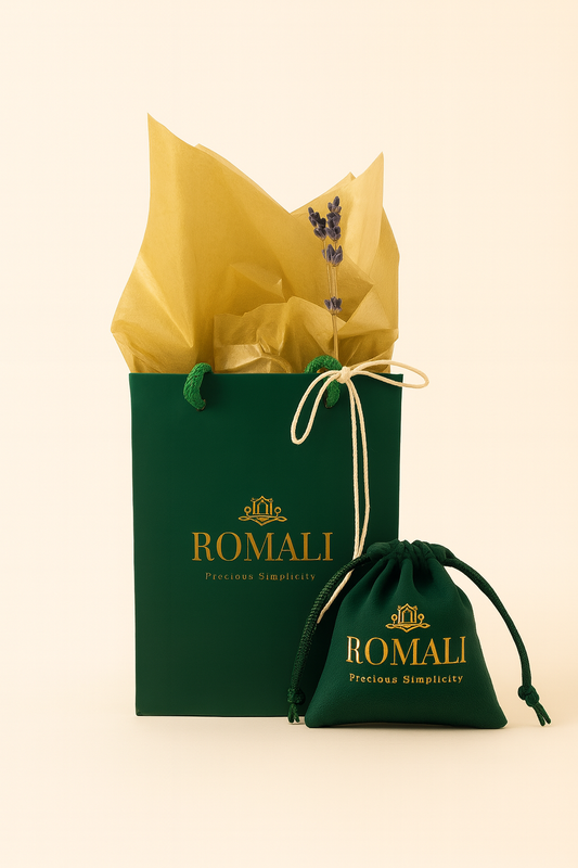 Green gift bag and pouch with yellow tissue paper featuring the Romali brand on a beige background.