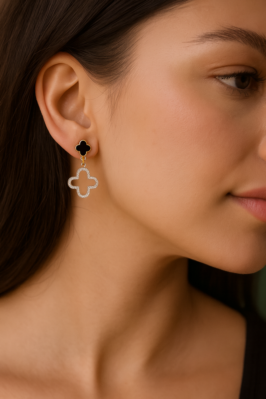 Close-up of a woman wearing a gold clover-shaped earring.