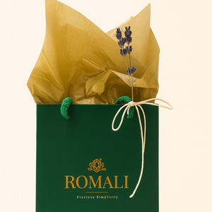 Green gift bag with gold interior and 'ROMALI' branding on a beige background