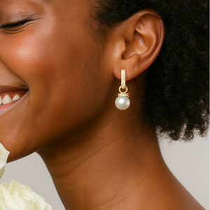 Close-up of a woman wearing a pearl earring with a neutral background